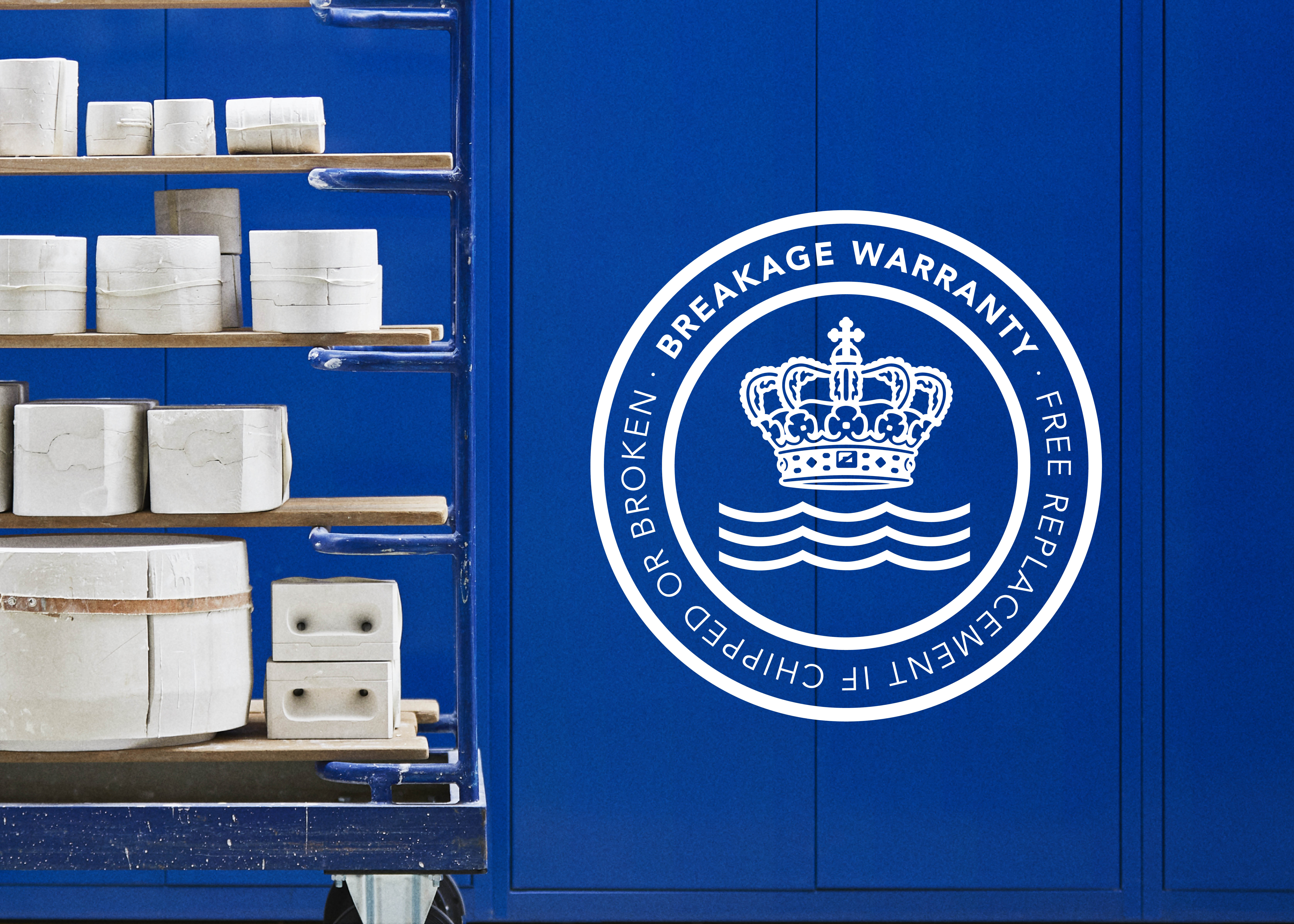 the symbol of the Royal Copenhagen Breakage Warranty on a royal blue colour
